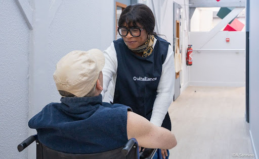 Personne âgée en fauteuil roulant avec une auxiliaire de vie