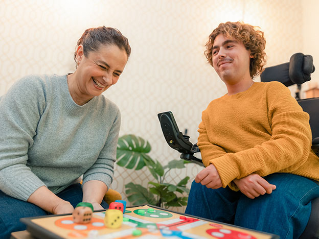 Une personne handicapée et son accompagnatrice jouant à un jeu de société