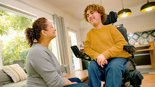 Auxiliaire de vie et une personne en fauteuil roulant