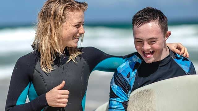 Une accompagnatrice à la plage avec une personne handicapée